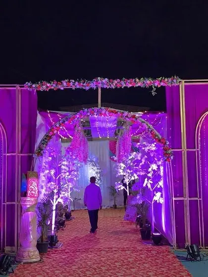 A grand entrance structure for a purple-themed wedding. The multiple arches, chandeliers, and dramatic lighting set an impressive tone for the event.