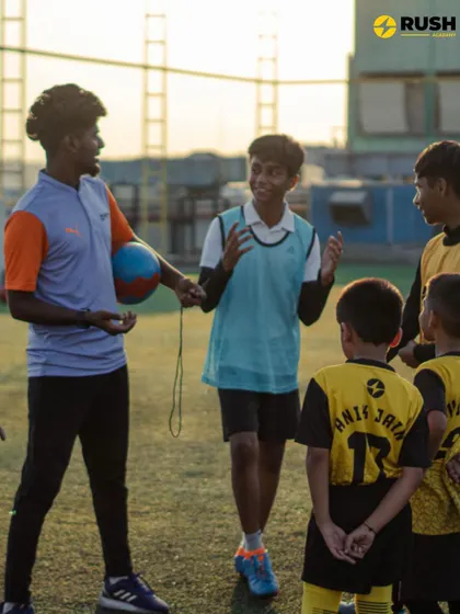 A coach and his team sharing a moment of discussion and laughter. A positive player-coach relationship is fundamental to our philosophy.
