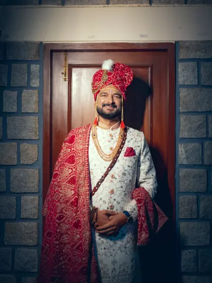 A smiling groom in his grand wedding sherwani, looking happy and ready for the ceremony.