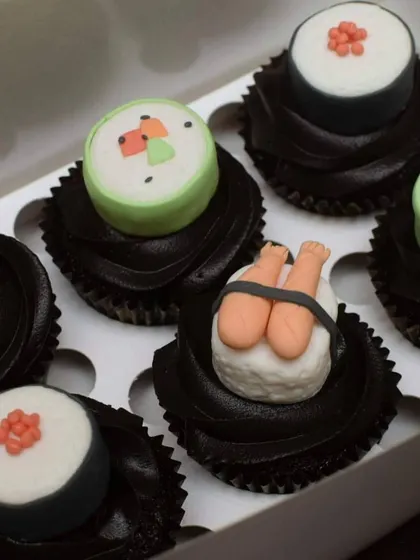 A close-up of the handcrafted fondant sushi toppers. I used different colours and shapes to create realistic-looking maki rolls and shrimp nigiri, placed on dark chocolate frosting to make the details pop.