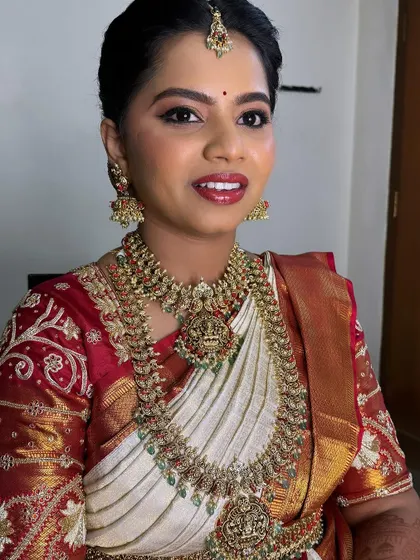 A close-up of Sahana's wedding day makeup. The look is classic and timeless, with a focus on her eyes and a perfectly matched lip color for her red and white saree.