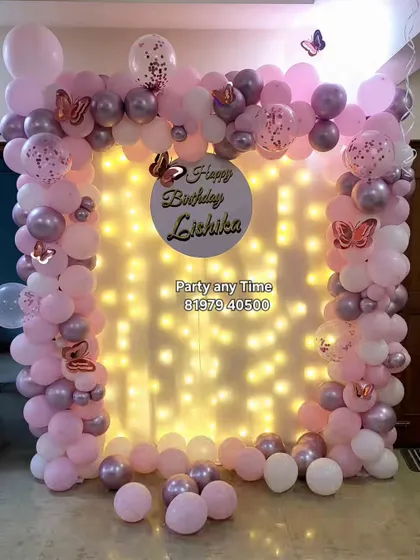 A closer view of the butterfly and fairy light backdrop. The pink and chrome balloons create a soft and elegant look.