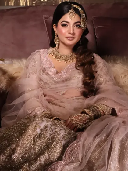 A full shot of a Muslim bridal look, showcasing the heavy jewelry, the soft pink lehenga, and the overall regal feel.