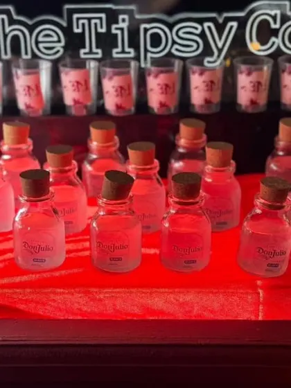 Another look at our custom-bottled Don Julio shots. The personalized labels and neat presentation on a red tablecloth make this a premium and well-organized shot station.