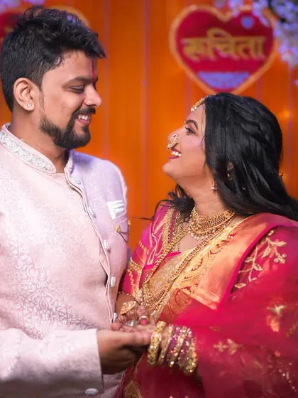 A joyful, candid shot of the couple laughing together during their ceremony. The vibrant colors of the decor and their outfits add to the celebratory feel.