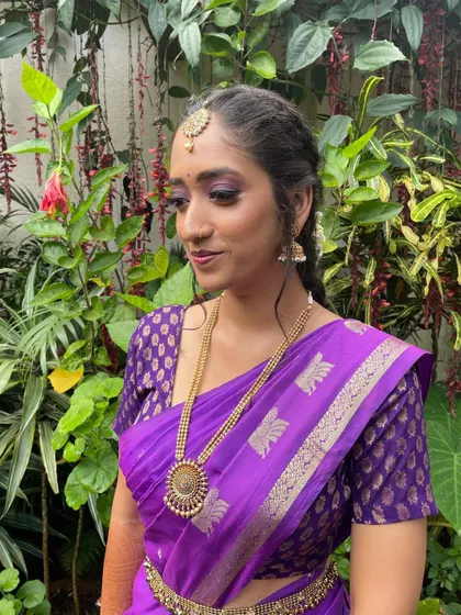 A side profile showing the elegant hairstyle and how the makeup looks from different angles. The purple eyeshadow adds a pop of color that is both modern and traditional.