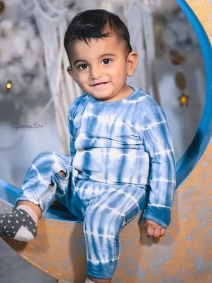 A happy toddler enjoying the celestial moon set. The soft, cloud-like floor is perfect for babies who are sitting or crawling, ensuring they are comfortable throughout the shoot.