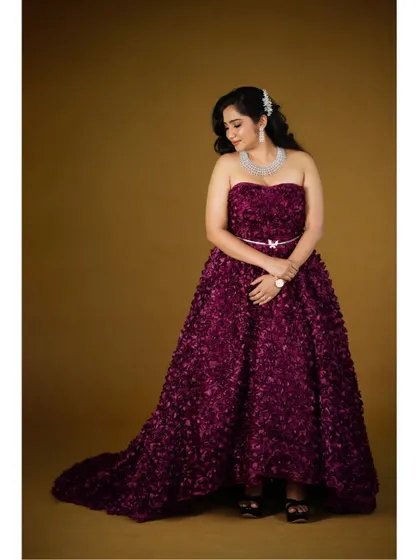 A full-length portrait showing the beautiful texture and flow of the wine floral gown.
