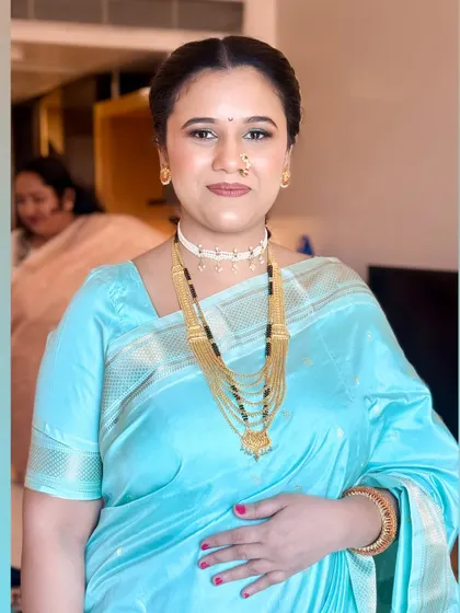 A close-up of her makeup, featuring a subtle green shimmer on the eyelid that beautifully picks up the color of her saree.