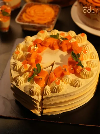 A table of tropical dreams. Our Mango Cream Cake, sliced and ready to serve, surrounded by other mango-themed treats from our seasonal menu.