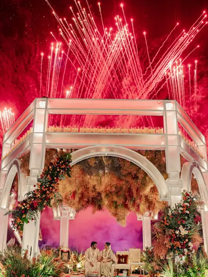 A truly explosive moment of celebration, with fireworks erupting behind the mandap as the couple sits for their ceremony. This is how I create unforgettable drama.