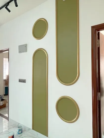 An on-site photo showing the progress of a decorative wall feature with olive green and gold-trimmed panels. This captures the moment where our design concept begins to take its final, colorful form.