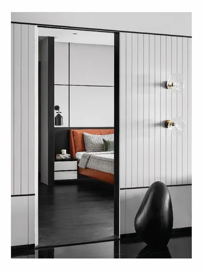An inconspicuous door in the living room slides open to reveal the master bedroom. This seamless transition maintains the clean, minimalist aesthetic of the home while creating an element of surprise. The custom bed and wall paneling await inside.