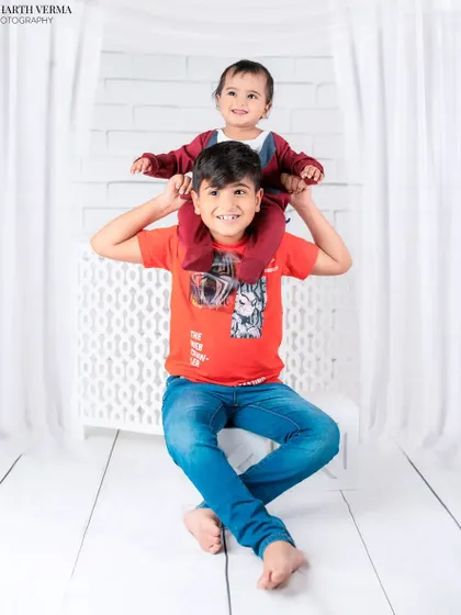 A playful moment between two brothers, with the younger one enjoying a piggyback ride on his older brother's shoulders. It’s a photo full of laughter and energy.