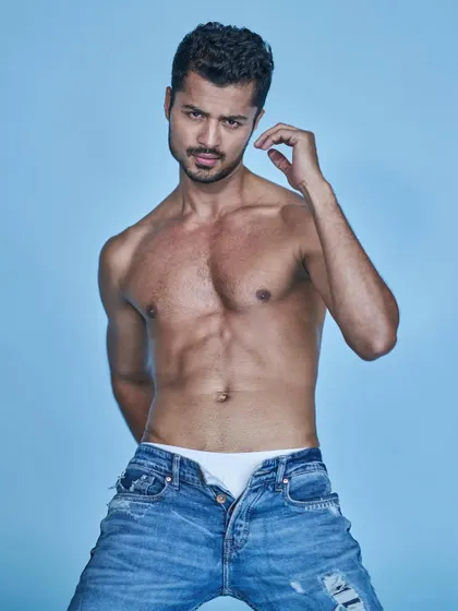 An intense and direct look from a denim-themed studio shoot, showcasing both physique and expression.