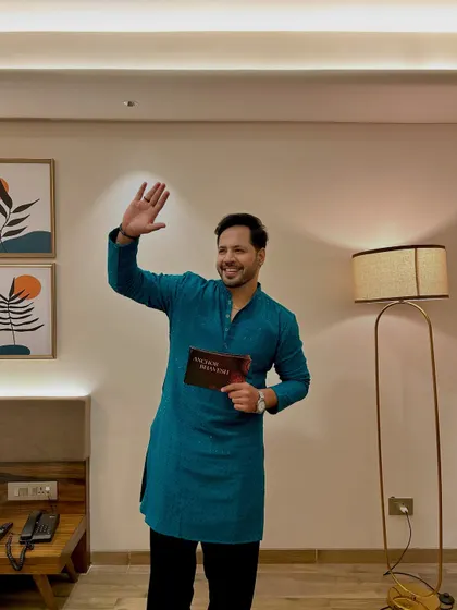 Holding a 'Big FM' podcast sign while waving. This shows my association with other media platforms and adds to my credibility.