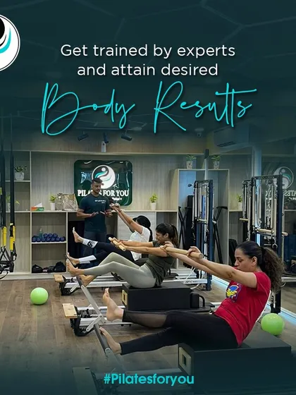 Under my guidance, a group class works on the Teaser, a challenging exercise that requires significant core strength and control. I ensure everyone maintains proper form for maximum benefit.