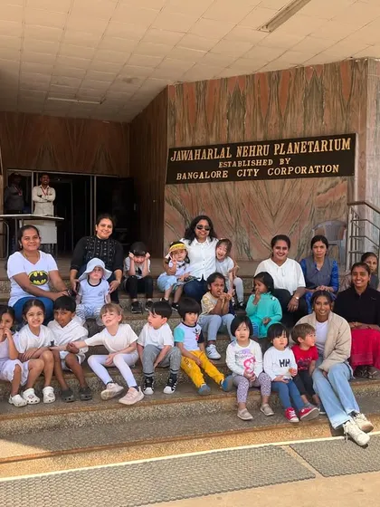A group photo of our students, teachers, and parent volunteers on the steps of the planetarium after a day of exploration.