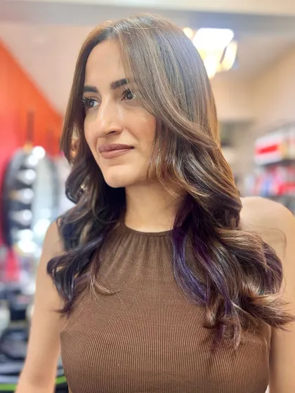 A happy client with her new haircut and color, featuring a subtle purple peekaboo. Making bad hair disappear is my specialty.