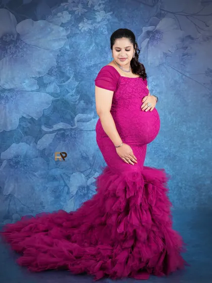 A beautiful mermaid-style gown in a striking magenta color. The ruffled tulle at the bottom adds texture and drama, making for a truly memorable portrait.