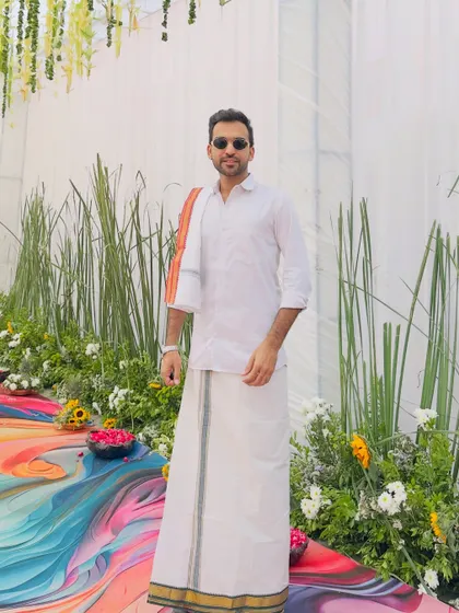 A full-length view of my South Indian attire against a colorful, modern backdrop. I ensure my look complements the event's decor and theme perfectly.
