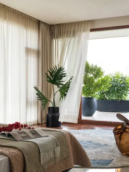This guest bedroom at Timber Edge opens onto a breezy balcony, blurring the line between the interior sleeping space and the outdoor lounge area.