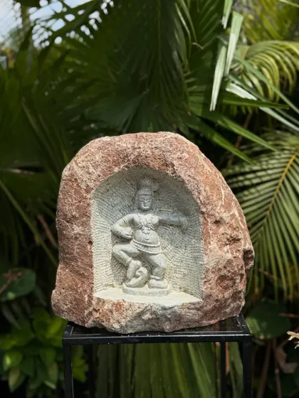 This natural rock carving depicts Kaliya Mardana, where Krishna dances on the serpent Kaliya, a dynamic and spiritual piece for your garden.