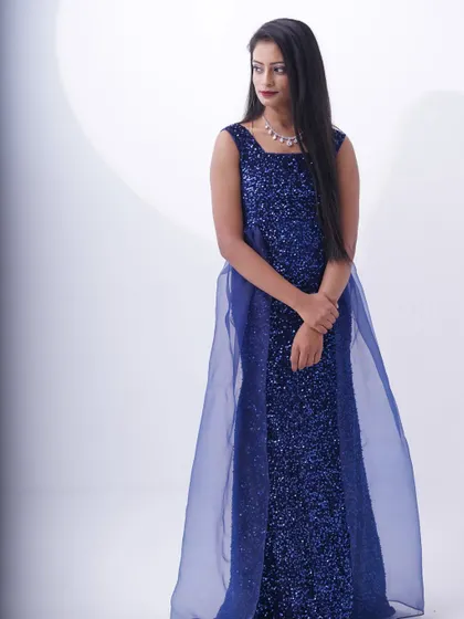 An elegant royal blue sequin gown with a sheer overlay, perfect for a sophisticated and glamorous look.