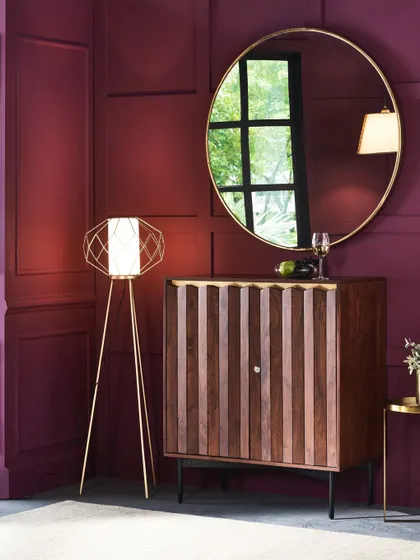 A corner vignette featuring a geometric floor lamp and a minimalist bar cabinet. This image demonstrates how to create a stylish and functional space, showing how different pieces from a collection can work together.