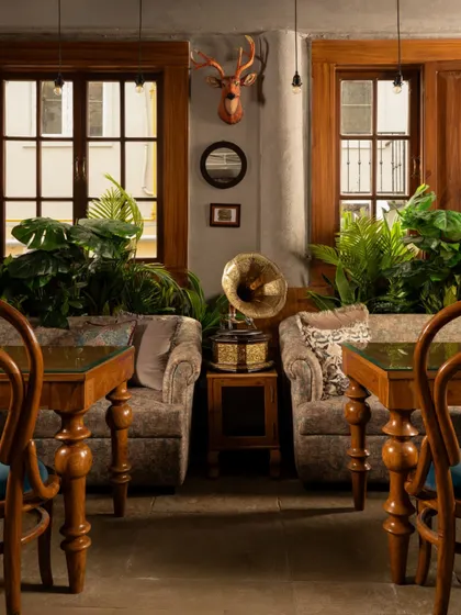 Unveiling the living room at Echoes, a space that reimagines the comfort of home. The vintage gramophone, plush armchairs, and warm lighting create a nostalgic atmosphere where guests can unwind.