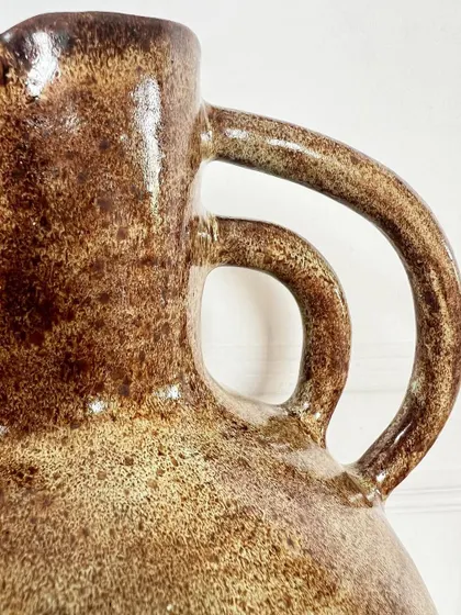 A close-up of the handle and the textured glaze on the large hand-built vase.