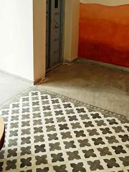 A work-in-progress photo showing the installation of custom printed cement tiles next to a vibrant wall mural, illustrating how I plan for every detail to flow together.