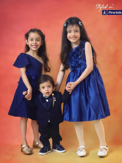 Side by side, connected by the heart. These three siblings, two sisters and their little brother, look so adorable and stylish in their matching blue outfits.