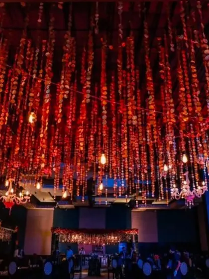 A ceiling view of a sangeet hall, where I used hundreds of hanging red sequin strings and vintage bulbs. This creates a mesmerizing effect over the entire space.