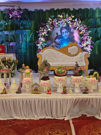 A wider view of the Thai-themed baby shower setup, showing the main seating area with a Yashoda-Krishna backdrop and our elaborate fruit and dessert tables.