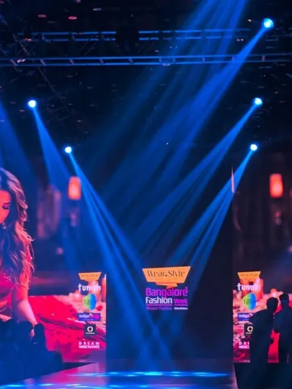 Setting the scene at Bangalore Fashion Week. I captured this shot to show the scale of the event, with the dramatic blue spotlights and branding creating an exciting atmosphere before the show begins.