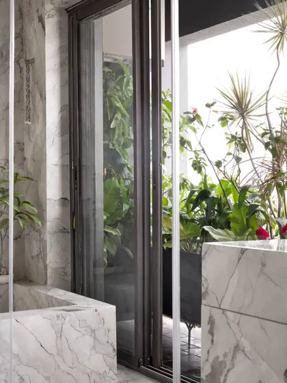 The master bathroom in our Bengaluru project opens up to a private balcony filled with plants. It creates a spa-like experience, allowing you to bathe surrounded by nature, 20 floors up.