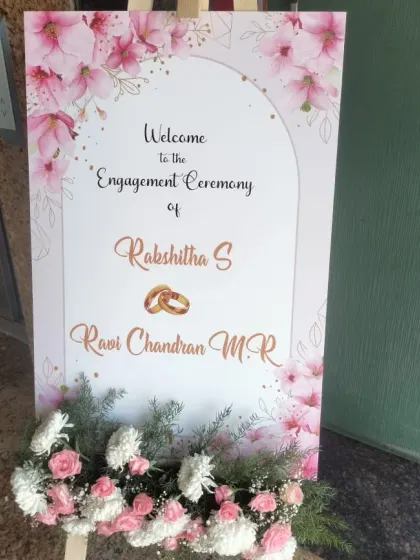 A beautifully designed welcome sign for Rakshitha and Ravi Chandran's engagement ceremony, featuring a pink floral watercolor theme.