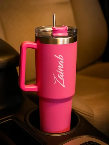 My large-capacity travel tumbler in hot pink, customized with the name "Zainab". The handle and straw-friendly lid make it perfect for taking on the go.