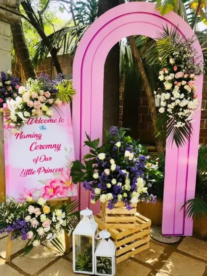 A stylish welcome setup for a princess-themed naming ceremony. The pink archway and floral arrangements create a beautiful photo spot at the entrance.