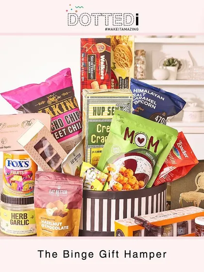 Another look at the "Binge Gift Hamper," overflowing with treats like popcorn, crackers, cookies, and chocolates in a stylish striped box.