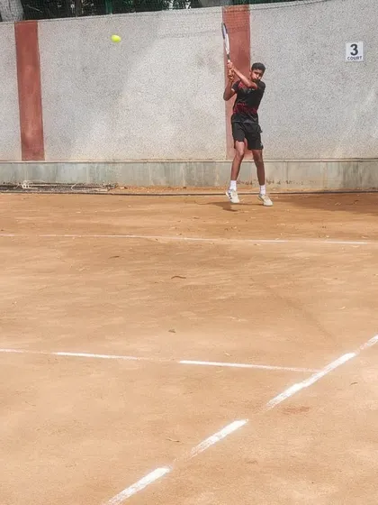 A young player executing a powerful forehand during an AITA U-16 tournament match. His form shows the result of countless hours of drilling and practice.