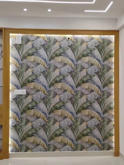 A living room with a tropical leaf wallpaper framed with backlighting, turning the wall into a stunning feature.