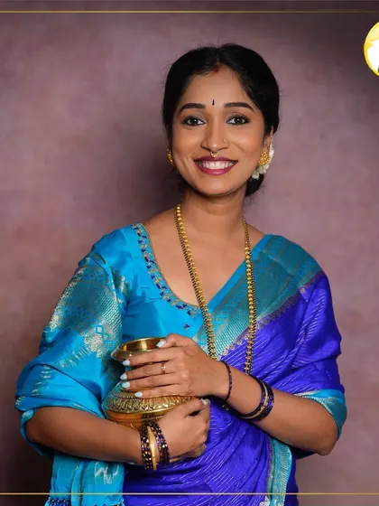 A full portrait showcasing the traditional attire. The makeup enhances her features, with a bright smile and radiant skin, making her look perfect for her special ceremony.