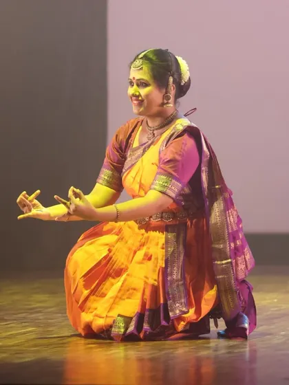 A seated Bharatanatyam pose, showcasing the intricate hand mudras and joyful expression that our students learn to master.