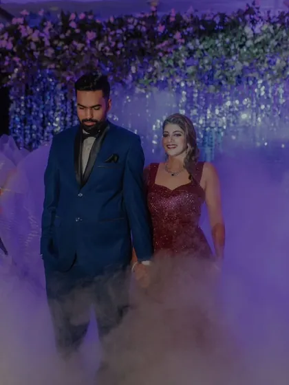 A grand, smoky entrance for the Sangeet night, with the couple looking glamorous and ready to celebrate.