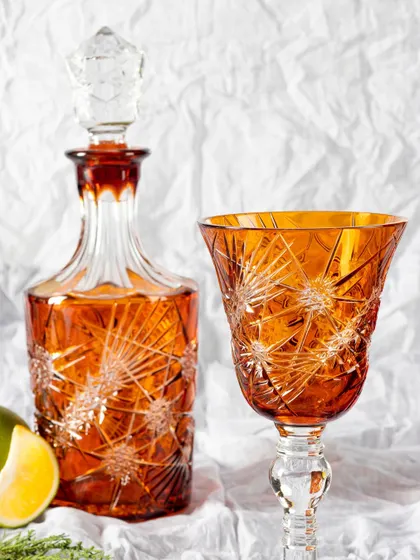 A styled shot of the same amber decanter set, this time on a white, textured background with a slice of lime for a pop of color. This shows the product in a lifestyle context.