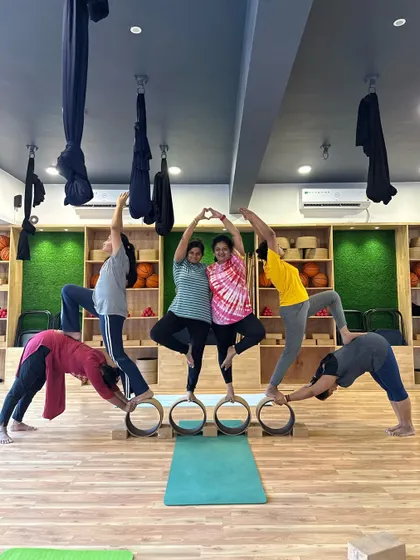 A creative and beautiful group pose using yoga wheels to form a flower-like shape. This is what our Hamsa community is all about.
