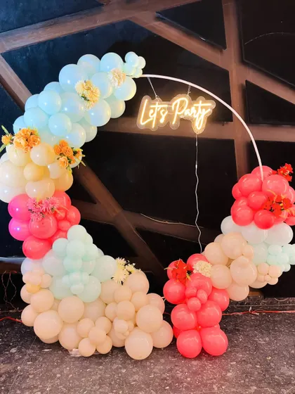 A colorful pastel balloon ring with a "Let's Party" neon sign, perfect for any fun celebration.