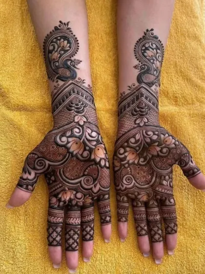A classic and elegant design featuring graceful peacocks at the top of the wrist. The palms are filled with delicate floral and paisley patterns, perfect for an engagement or sangeet ceremony.
